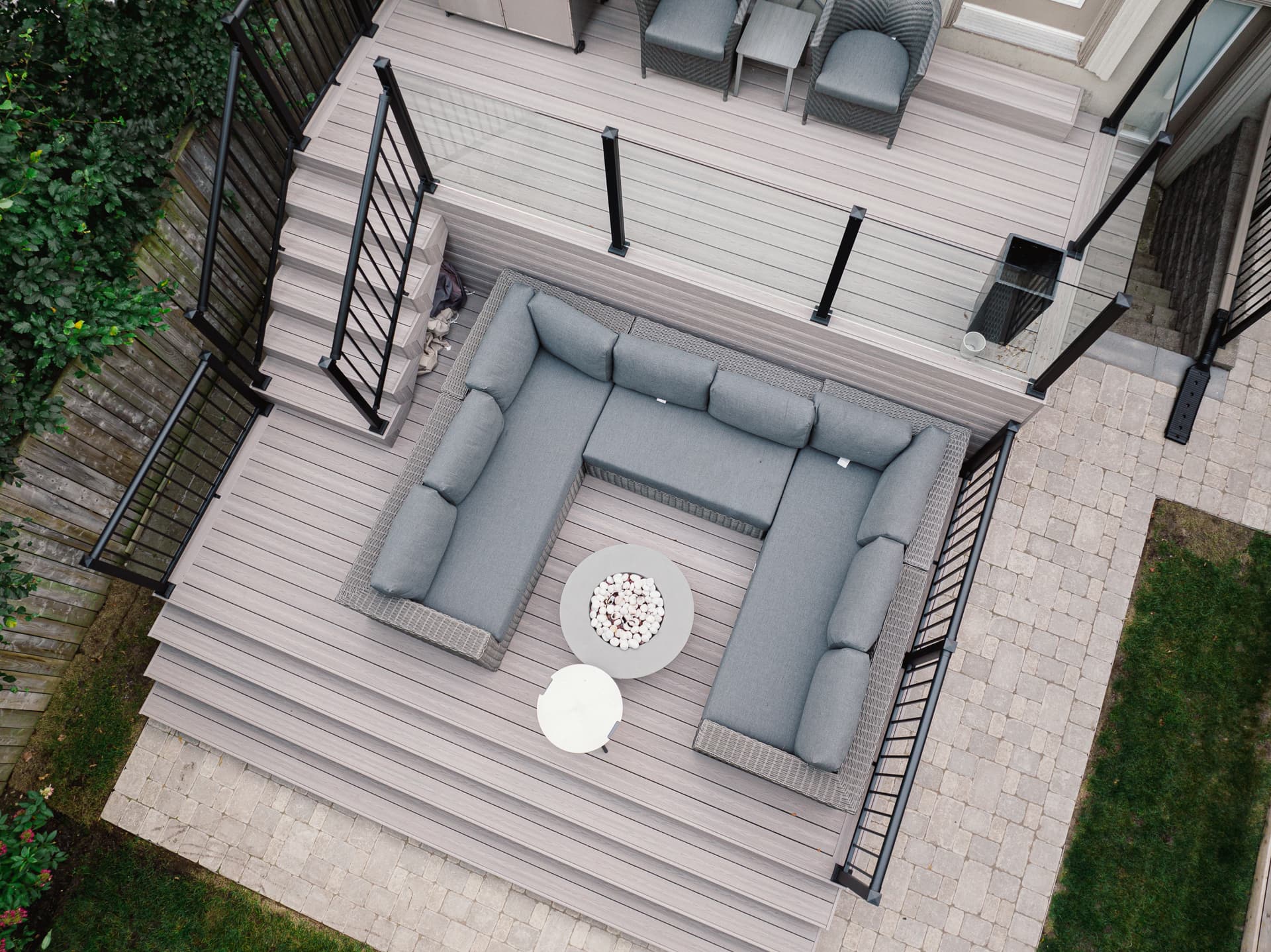Aerial view of a light composite deck with black aluminum railing and lounge furniture
