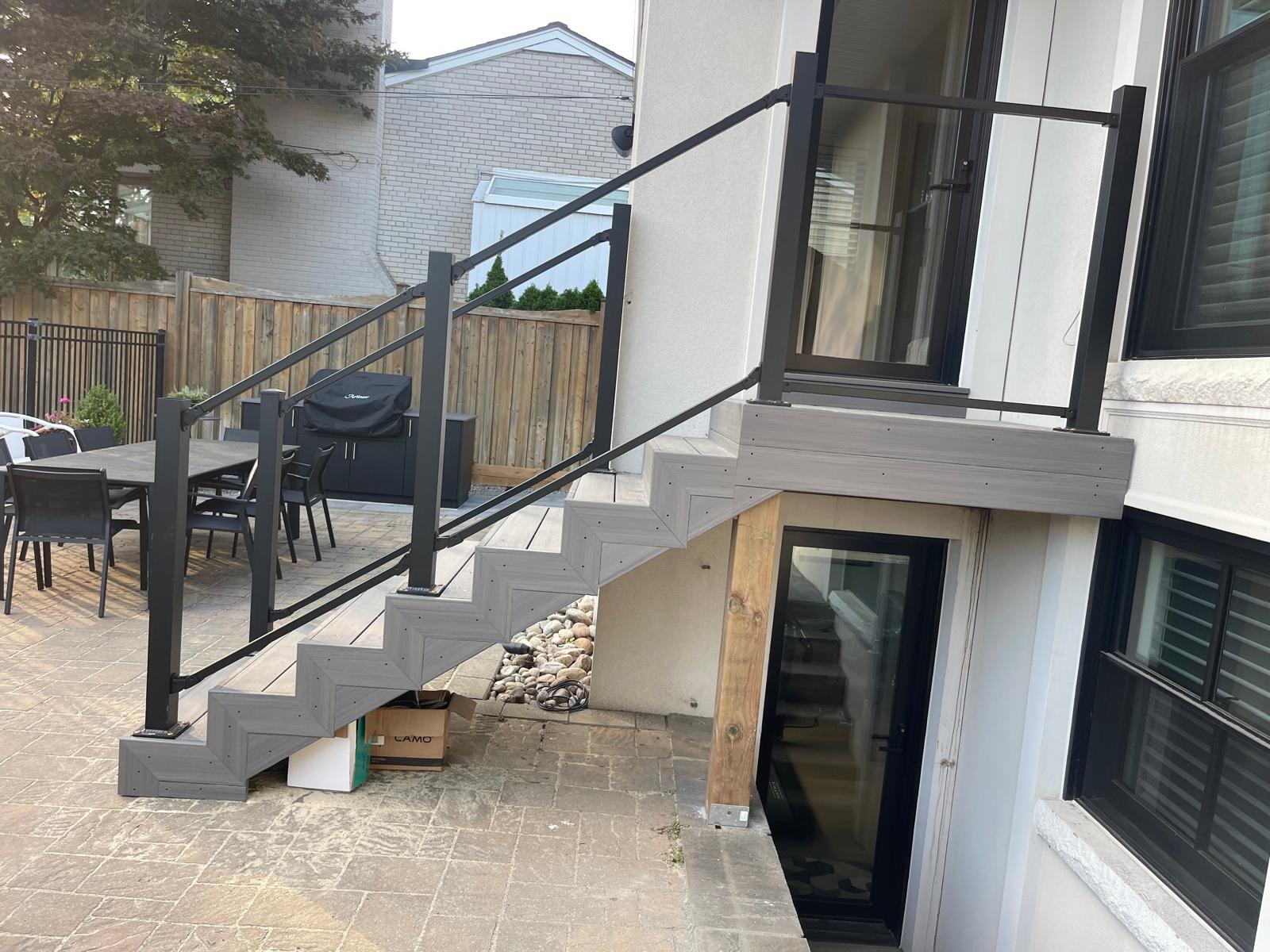 Escalier de patio composite avec rampe d’aluminium noire reposant sur une structure bien appuyée