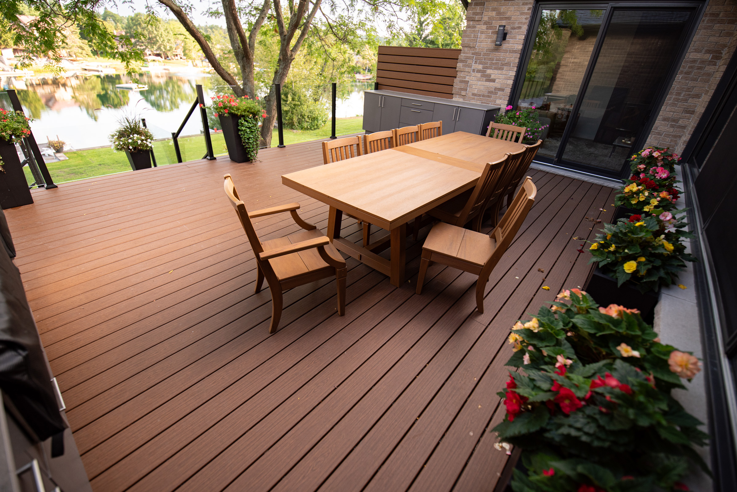 Lakeside composite deck dining area with glass railing